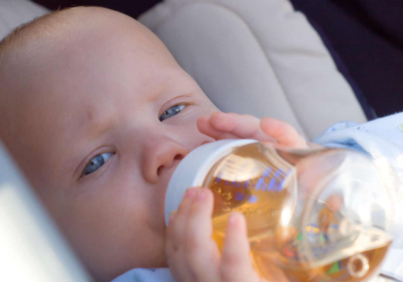 Beb&ecirc; tomando ch&aacute; na mamadeira