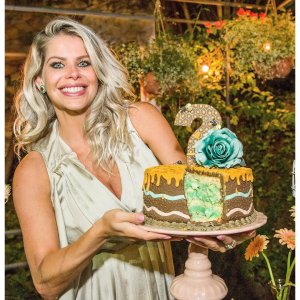 mulher sorri enquanto segura um bolo