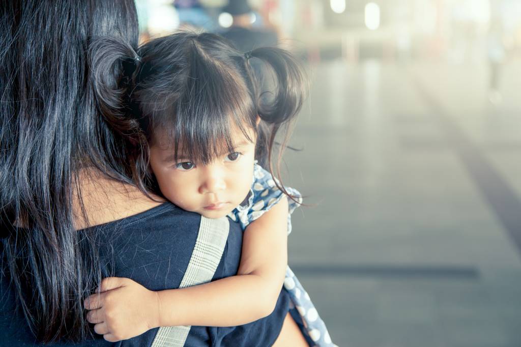 Menina abraçada à mãe