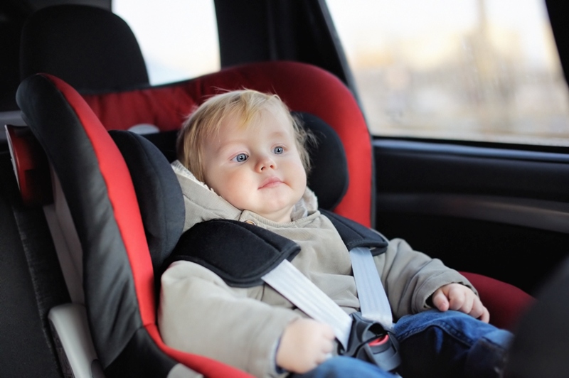 bebê sentado na cadeirinha do carro, no banco de trás