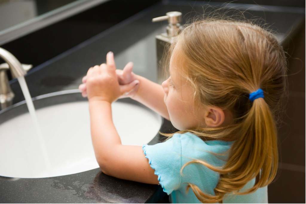 menina lavando as mãos