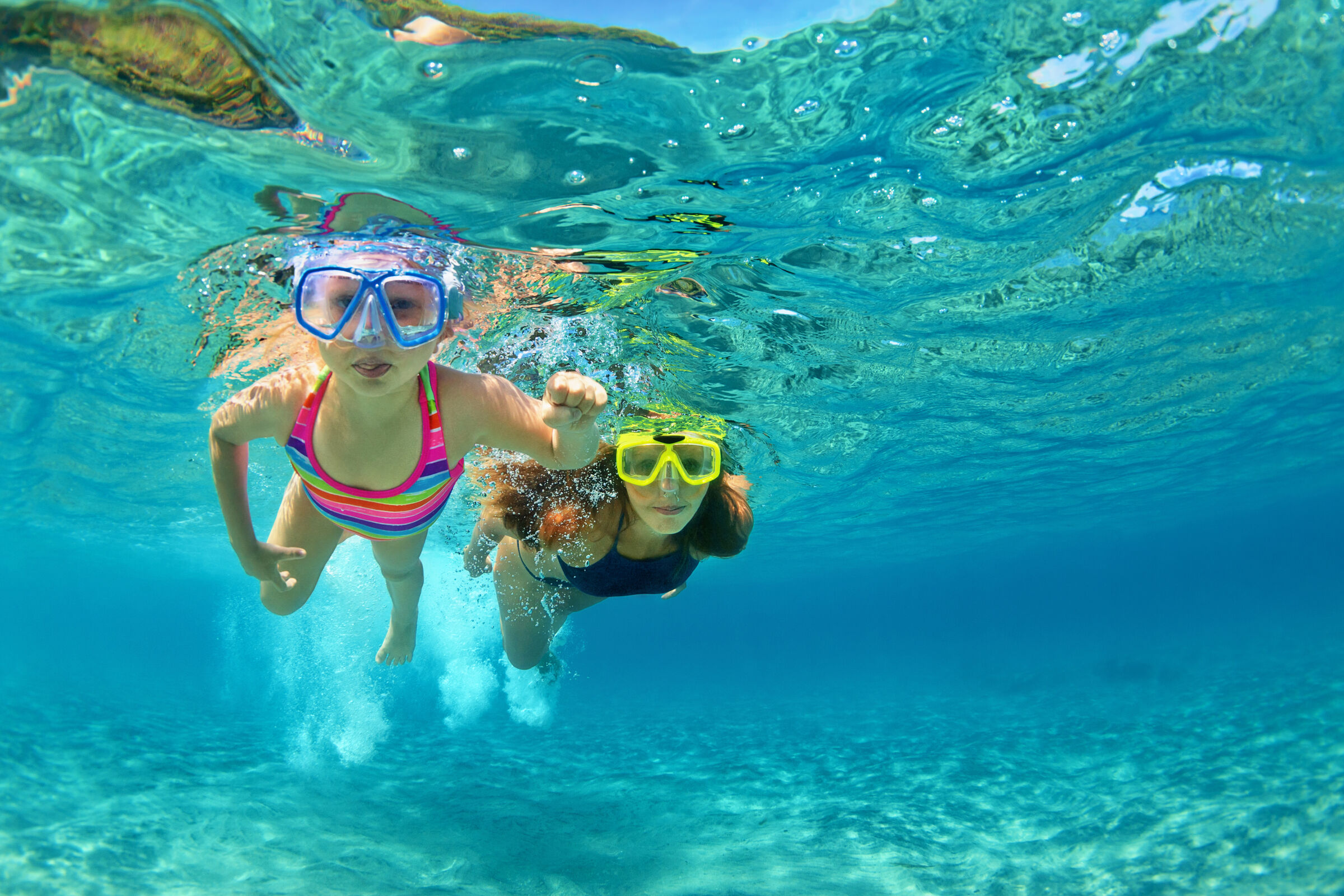 Mãe e filha fazendo mergulho nas férias