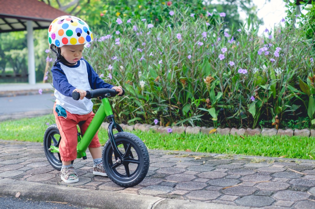 Criança andando de bicicleta usando capacete