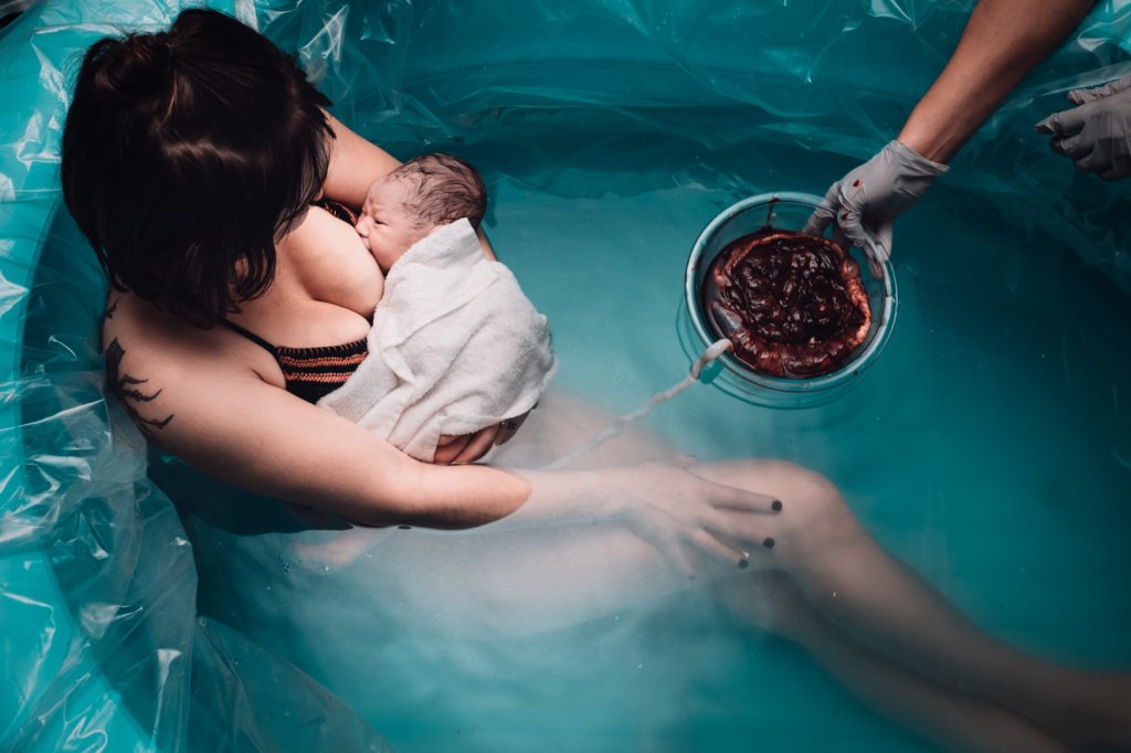 Mãe amamentando bebê após parto de lótus - concurso Birth Becomes Her