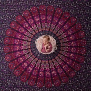 Bebê recém-nascido deitado em uma mandala vinho Bebê recém-nascido deitado em uma mandala vinho