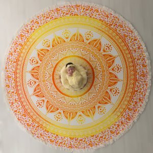 Bebê recém-nascido deitado em uma mandala amarela Bebê recém-nascido deitado em uma mandala amarela