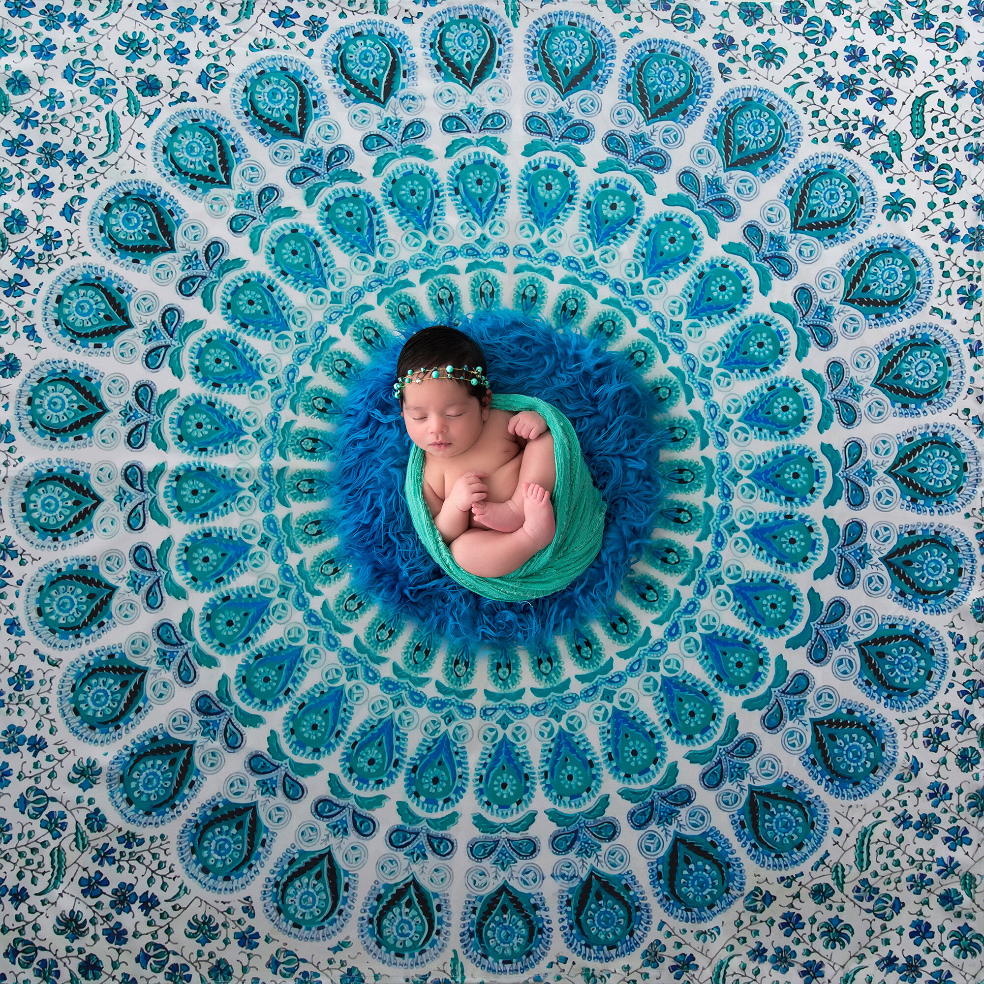 Bebê recém-nascido deitado em uma mandala turquesa