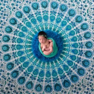 Bebê recém-nascido deitado em uma mandala turquesa Bebê recém-nascido deitado em uma mandala turquesa