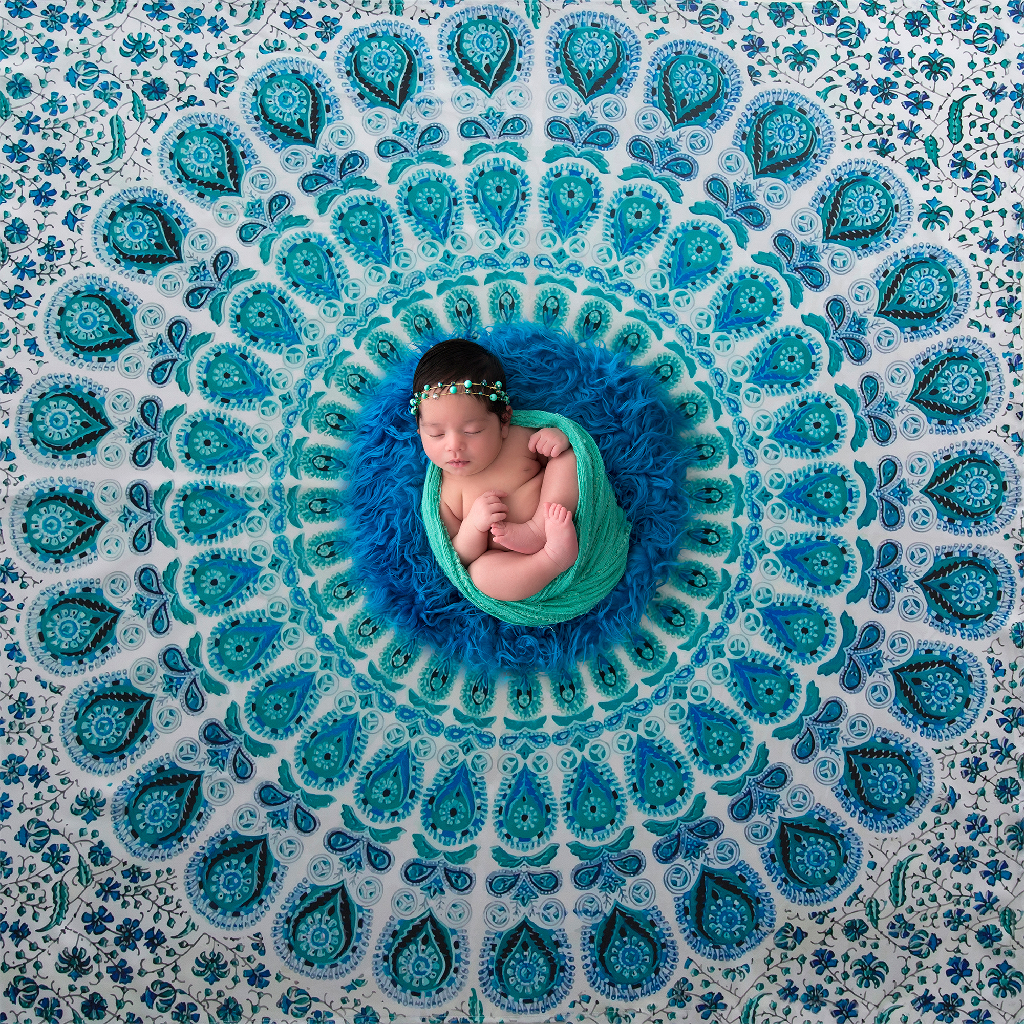 Bebê recém-nascido deitado em uma mandala turquesa