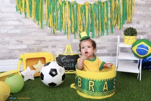 Bebê fantasiado com verde e amarelo para ensaio com o tema de Copa do Mundo