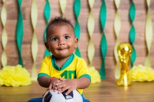 Bebê fantasiado com verde e amarelo para ensaio com o tema de Copa do Mundo