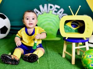 Bebê fantasiado com verde e amarelo para ensaio com o tema de Copa do Mundo