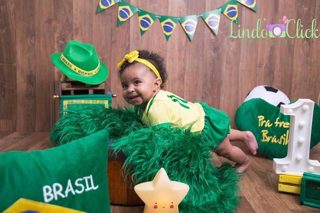 Bebê fantasiado com verde e amarelo para ensaio com o tema de Copa do Mundo
