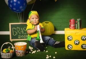 Bebê fantasiado com verde e amarelo para ensaio com o tema de Copa do Mundo