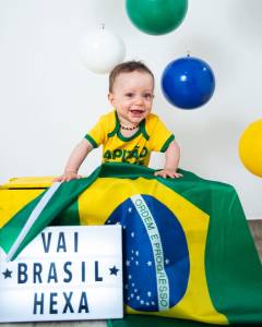 Bebê fantasiado com verde e amarelo para ensaio com o tema de Copa do Mundo