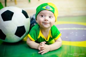 Bebê fantasiado com verde e amarelo para ensaio com o tema de Copa do Mundo