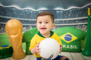 Bebê fantasiado com verde e amarelo para ensaio com o tema de Copa do Mundo