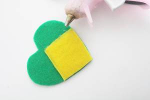 Recorte os excessos do feltro amarelo para que ele fique com o formato do feltro verde. Lembrancinhas de Copa do Mundo: chaveiros e garrafas personalizadas