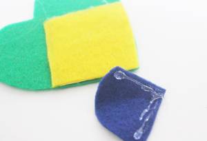 Recorte os excessos do feltro amarelo para que ele fique com o formato do feltro verde. Lembrancinhas de Copa do Mundo: chaveiros e garrafas personalizadas