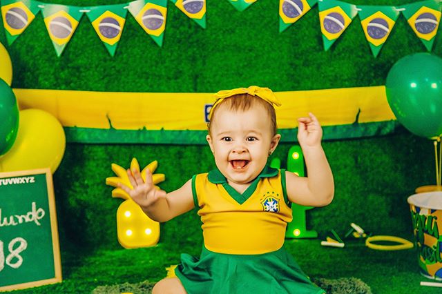 Bebê fantasiado de verde e amarelo para ensaio com o tema de Copa do Mundo