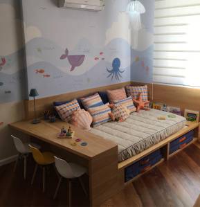 Quarto infantil com temática de fundo do mar, com uma cama embutida com escrivaninha de madeira