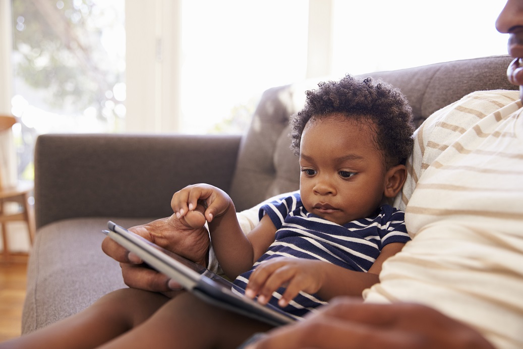 Criança usando o tablet com o pai