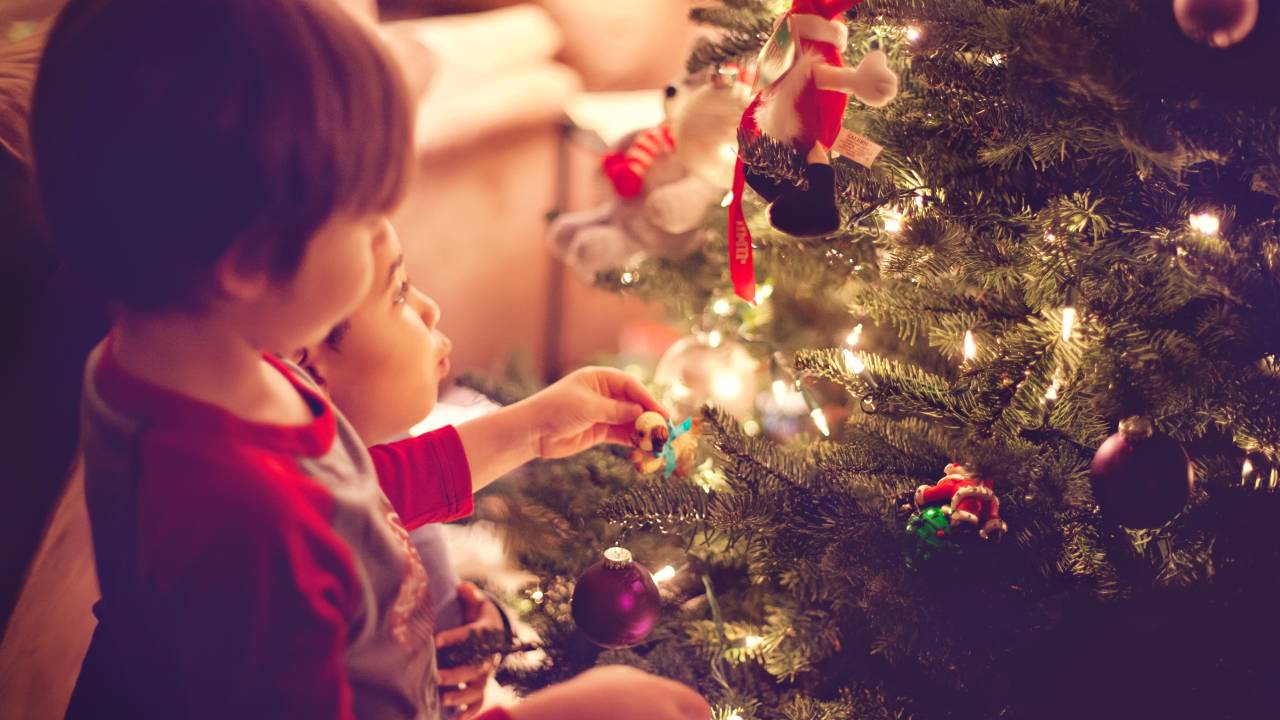 crianças mexendo na árvore de natal