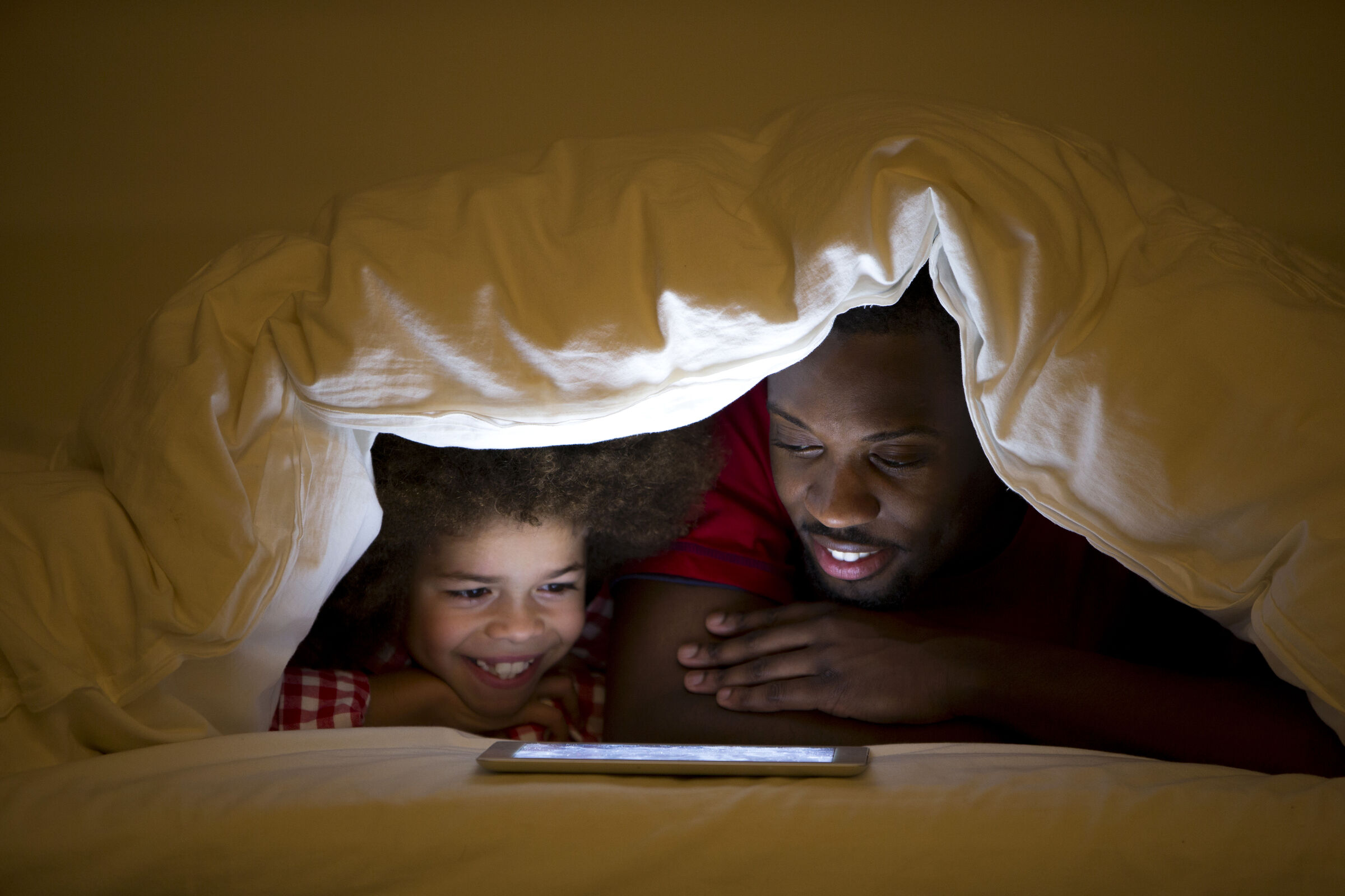 Pai e filha lendo no tablet