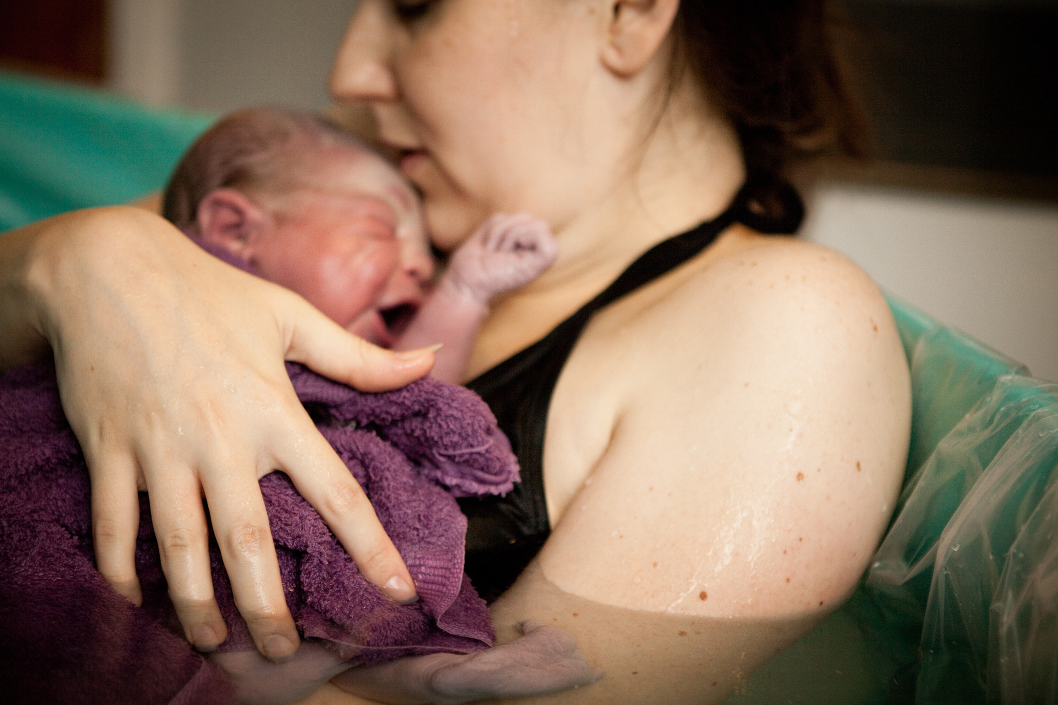 mãe segurando filho recém-nascido no pós-parto