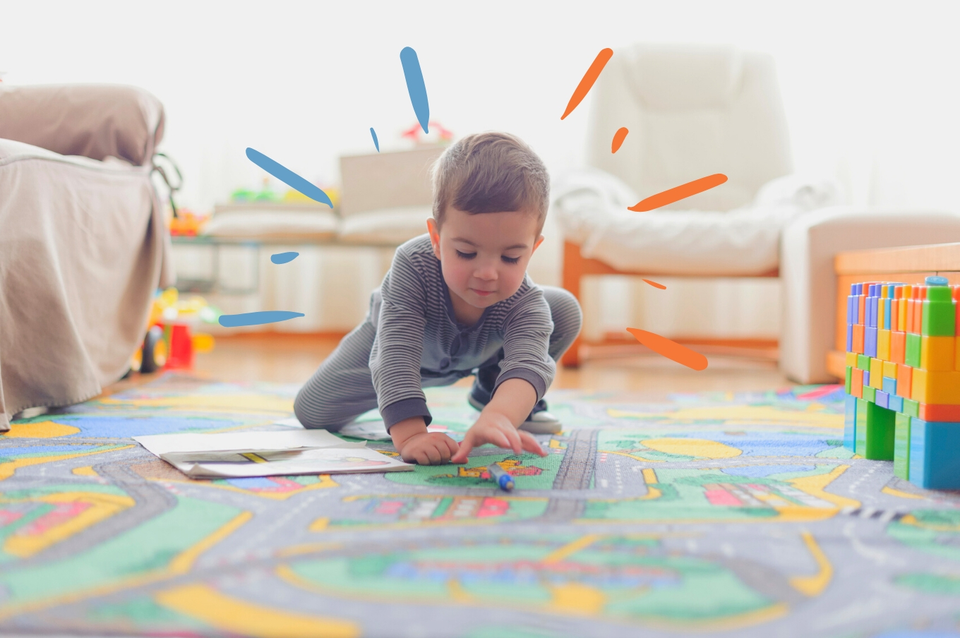 Menino, por volta de 3 anos, brincando sozinho ajoelhado no tapete colorido.