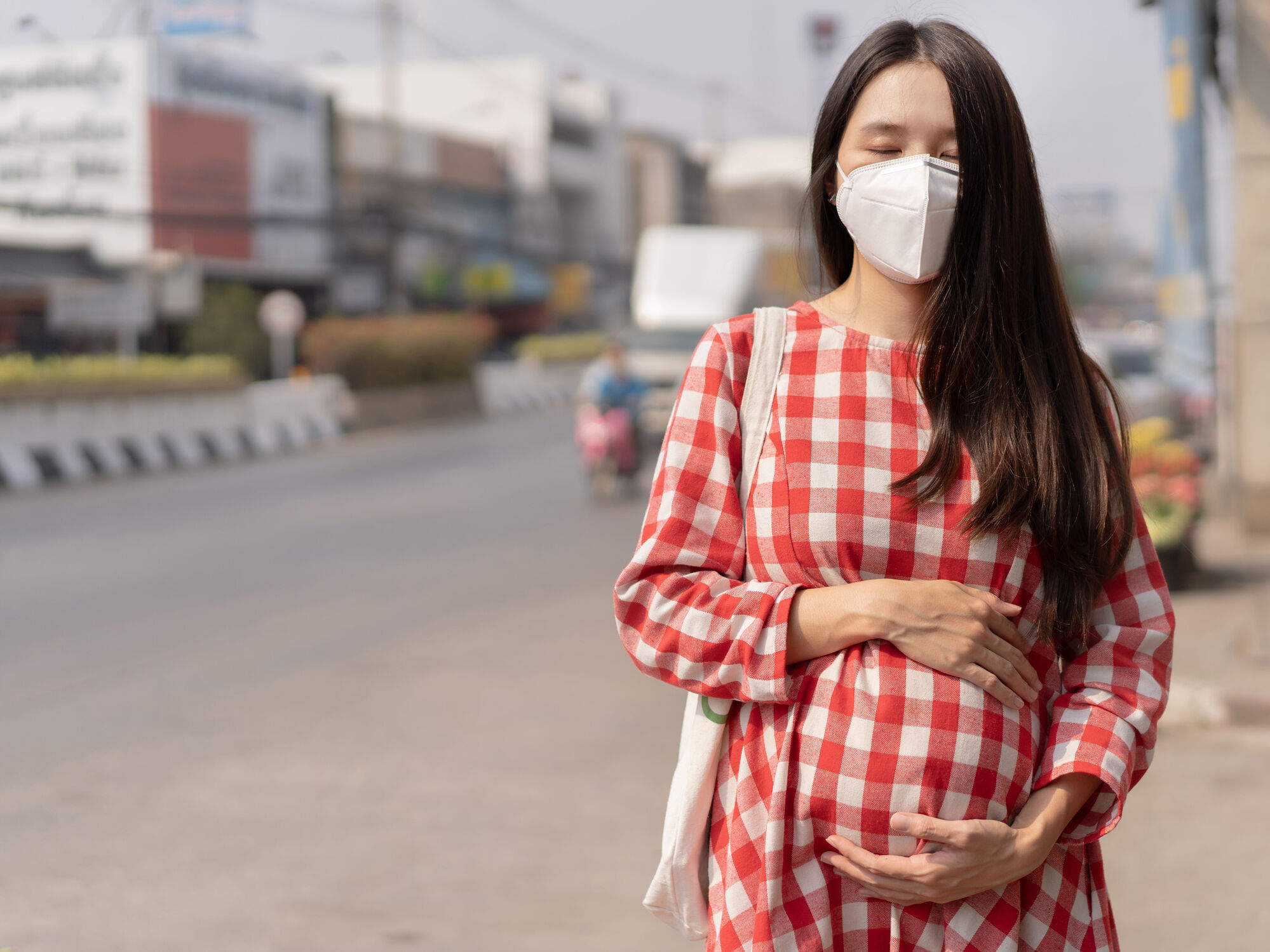 Mulher grávida em cidade poluída de máscara