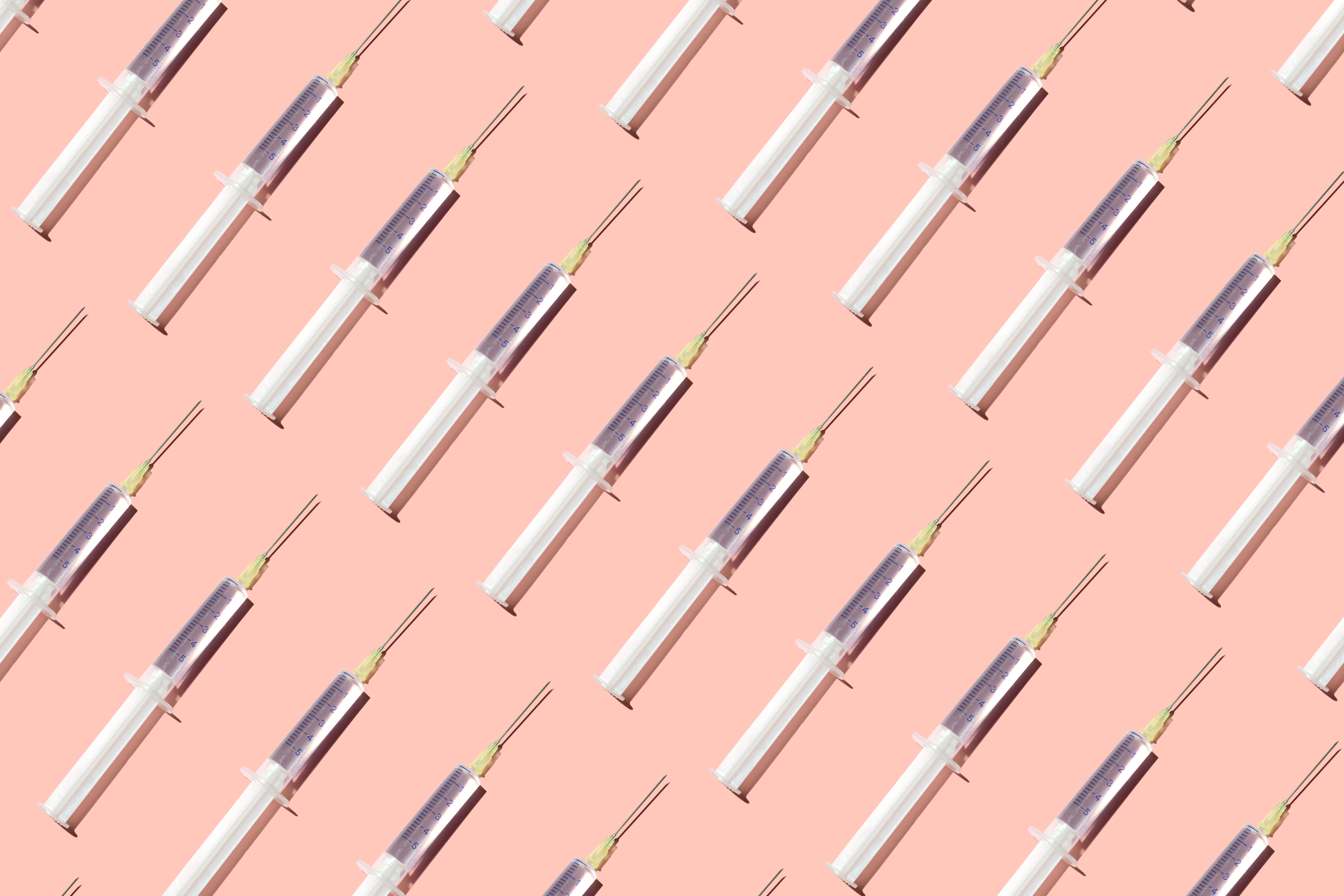 Ilustração de muitas seringas sobre fundo rosa claro.
