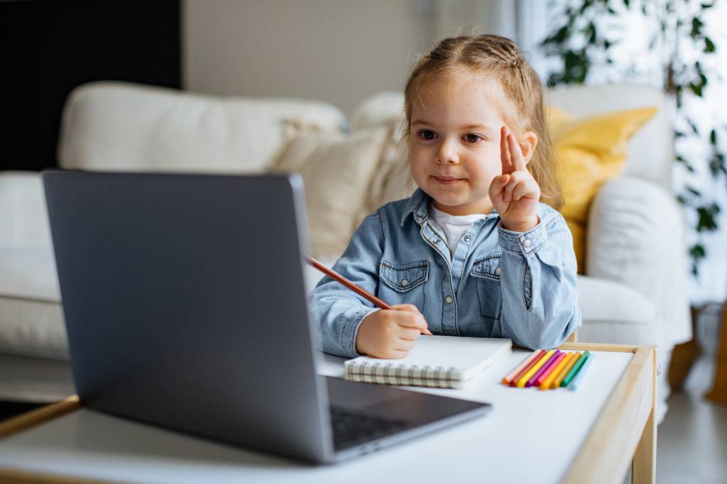 Criança pequena tendo aula à distância