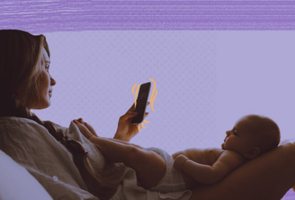 Mãe-olhando-celular-com-bebê-no-colo