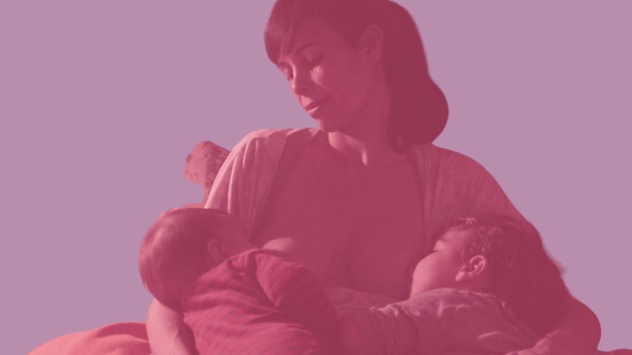 Mãe amamenta duas crianças