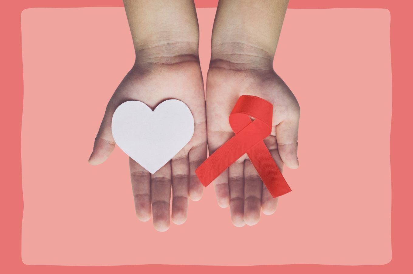 Mão de criança segurando símbolo da aids e coração