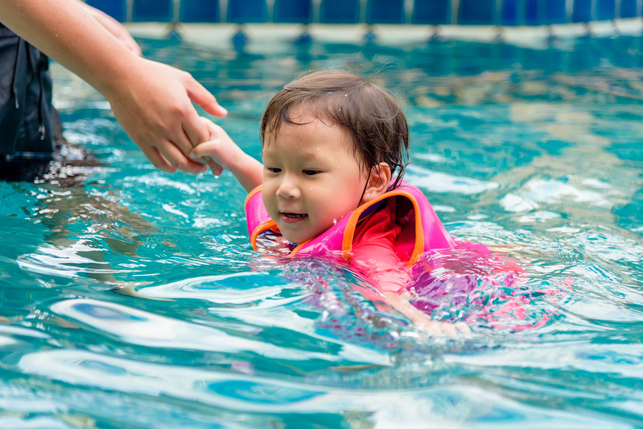 Criança nadando com colete salva-vidas