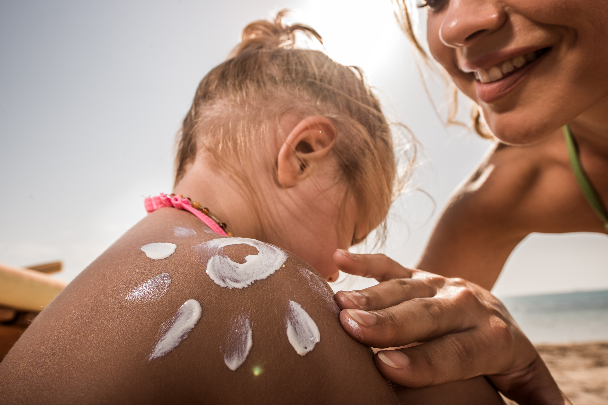 Criança com protetor solar no ombro