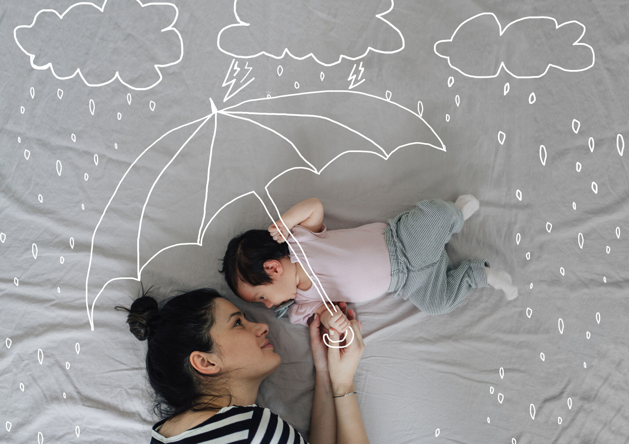 Mãe e bebê com ilustrações de chuva e guarda-chuva
