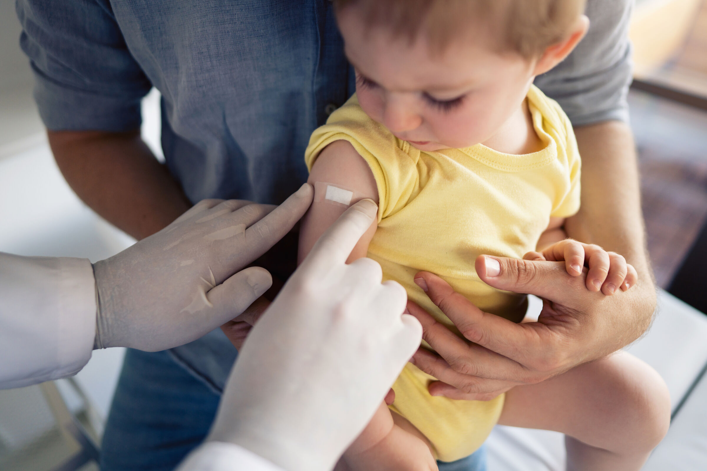 Médico-colocando-esparadrapo-no-braço-da-criança-depois-de-aplicar-a-vacina