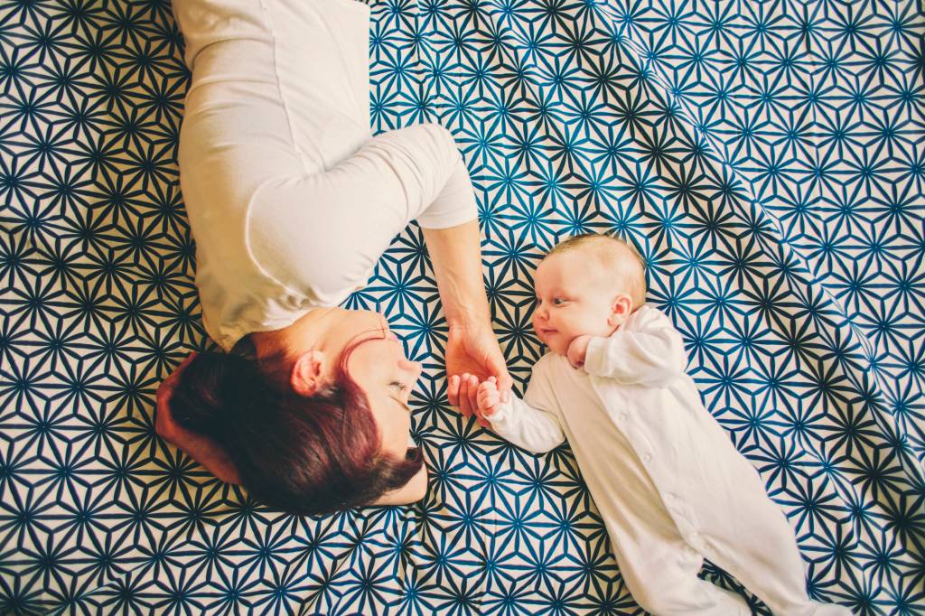 Mãe e bebê deitados na cama