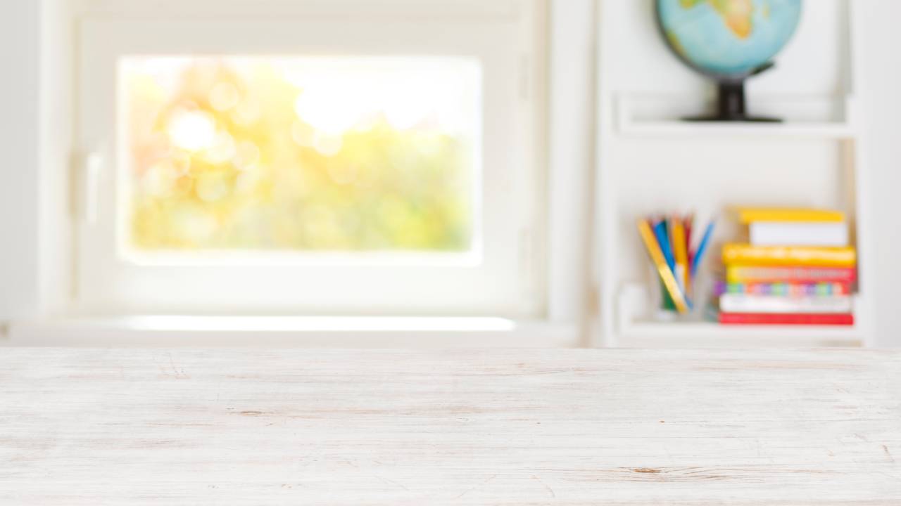 Mesa vazia e materiais escolares ao fundo