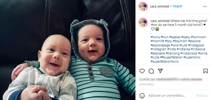 bebês gêmeos olham para a câmera e sorriem