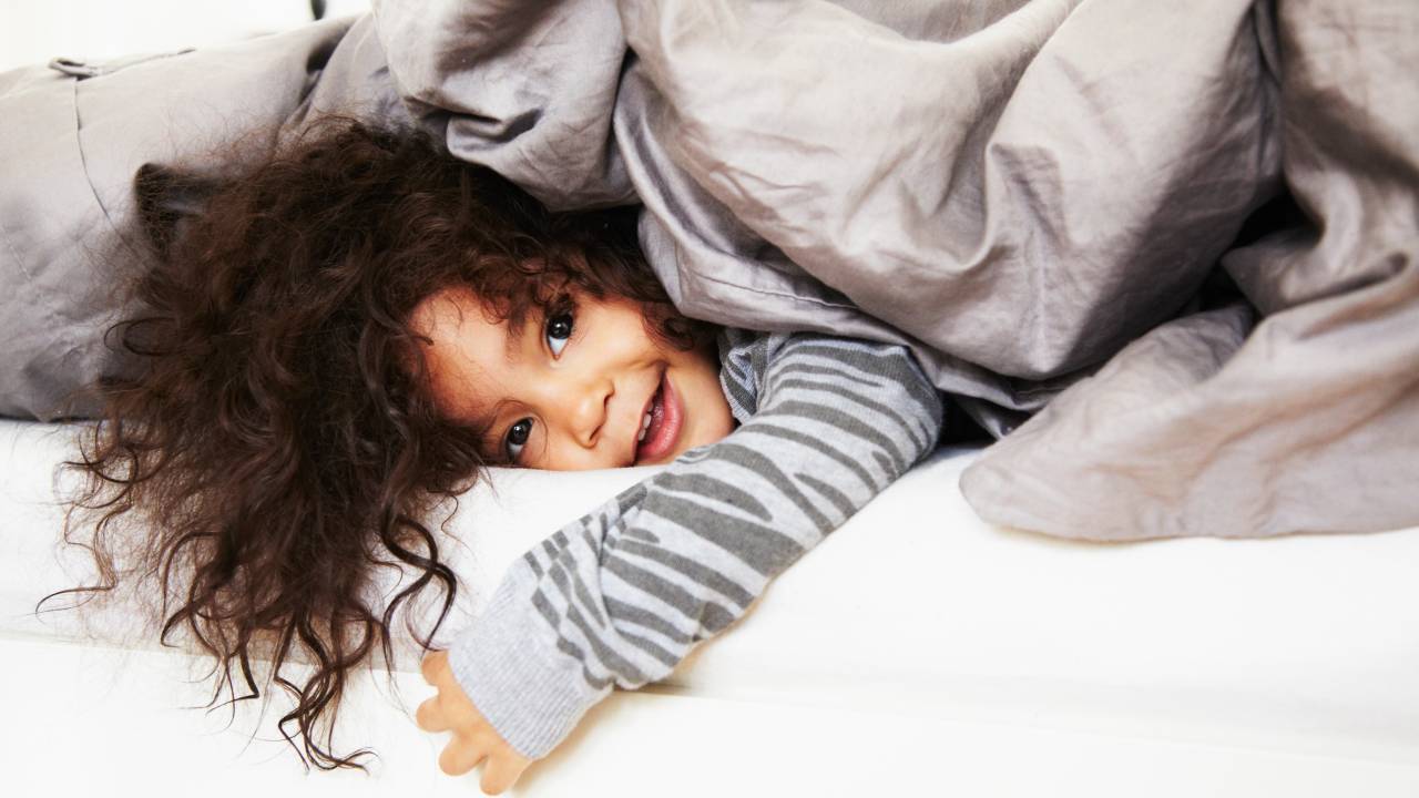 Criança coberta no inverno no quarto