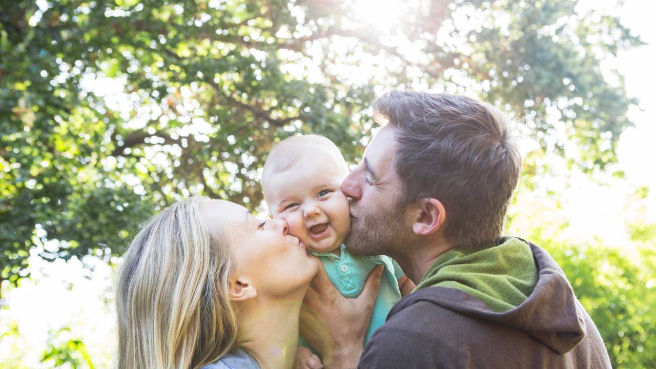 Pais com bebê família beijo