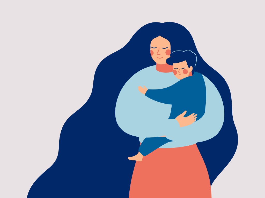 Mãe abraça filho no colo chorando e triste