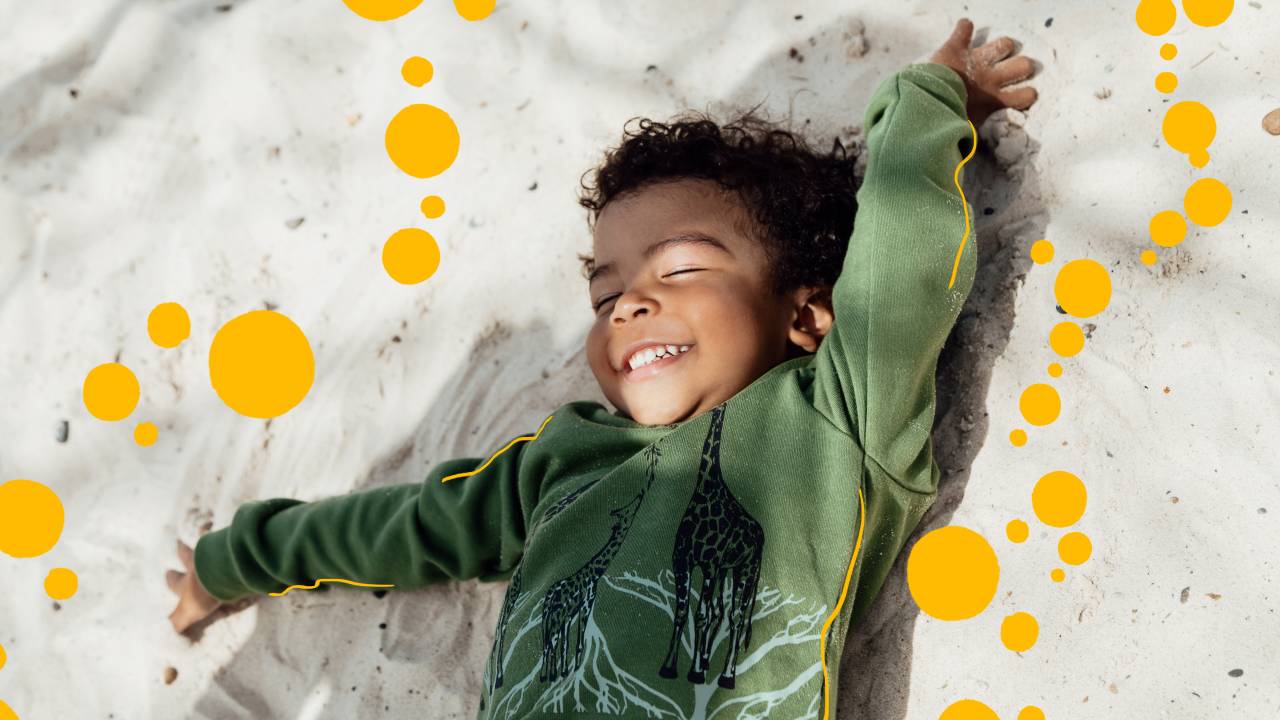 Um garotinho em uma praia e sorrindo