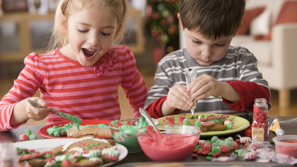 tradicoes-de-natal-final-do-ano-biscoitos menino e menina pintando biscoitos coloridos