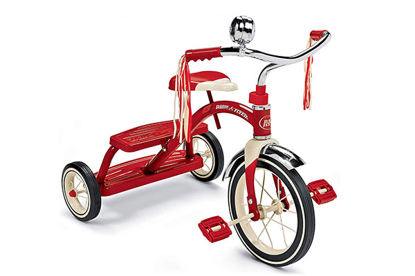 triciclo vermelho com detalhes em prata, buzina e fitas vermelhas penduradas no guidão