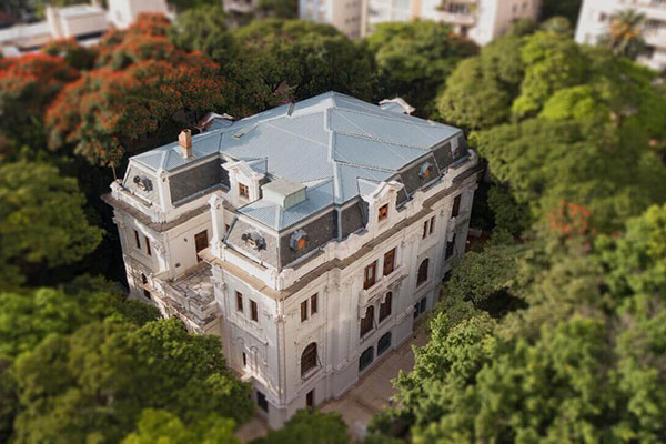 casão estilo palacete visto de cima, rodeado de árvores